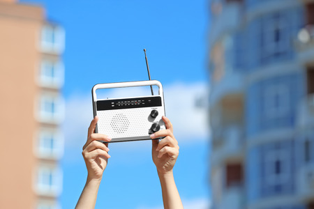 Woman holding radio, outdoorsの写真素材