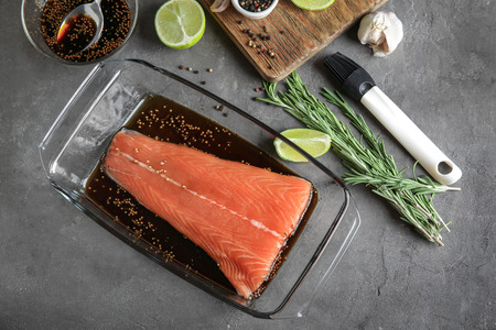 Salmon fillet with soy mustard marinade in baking dish on table