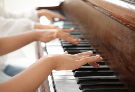 Little boy playing piano indoorsの写真素材