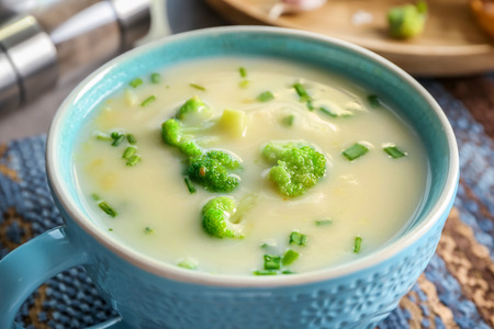 Cup of yummy potato soup with broccoli on tableの写真素材