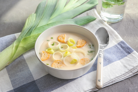 Bowl of yummy potato soup with leek and croutons on tableの写真素材