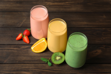 Glasses with different milkshakes on wooden backgroundの写真素材