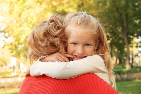 Cute little girl hugging grandmother in parkの写真素材