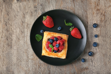 Plate with delicious pastry on wooden tableの写真素材