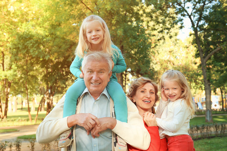 Elderly couple with granddaughters in park