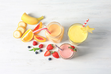 Glassware with different milkshakes on light backgroundの写真素材