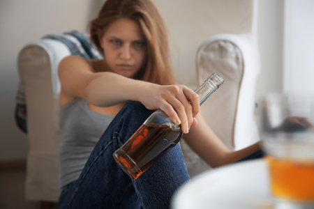 Young woman drinking alcohol at homeの写真素材