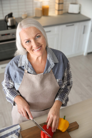 Beautiful mature woman cooking in kitchenの写真素材