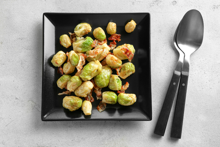 Plate with Brussels sprouts and bacon on tableの写真素材