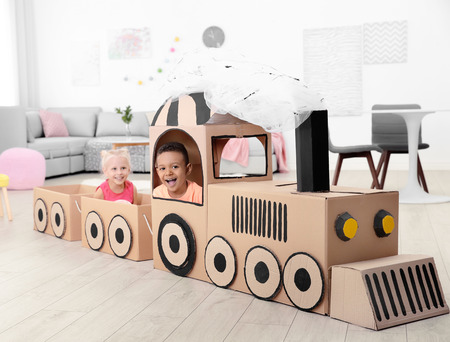 Cute children playing with cardboard train at homeの写真素材