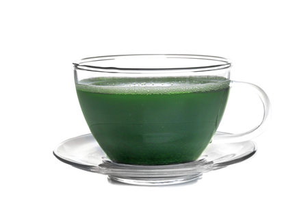 Cup of wheat grass juice on white backgroundの写真素材