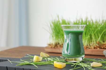 Shot of wheat grass juice on wooden boardの写真素材