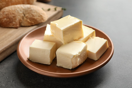 Plate with cubes of butter on tableの写真素材