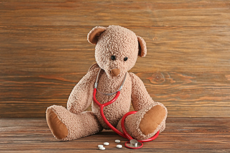 Cute teddy bear with stethoscope on wooden backgroundの写真素材
