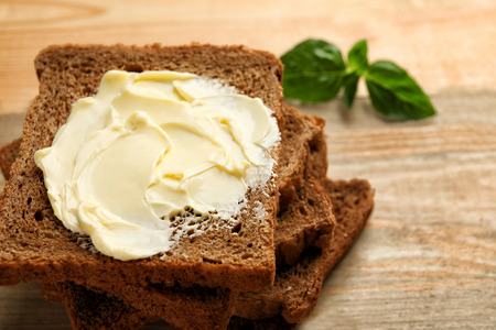 Rye bread with butter on wooden backgroundの写真素材