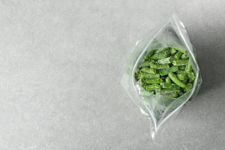 Plastic zipper bag with frozen green beans on grey backgroundの写真素材