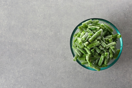 Glass bowl with frozen green beans on grey backgroundの写真素材