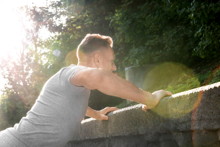 Mature sporty man warming up before running outdoorsの写真素材