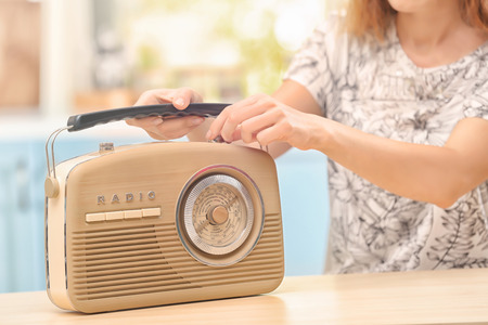 Young woman listening to radio in kitchenの写真素材