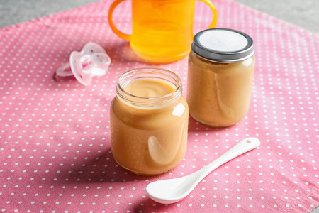 Jars with healthy baby food on tableの写真素材