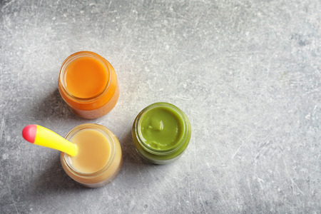 Jars with healthy baby food on tableの写真素材