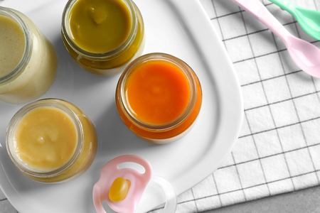 Jars with healthy baby food on tableの写真素材