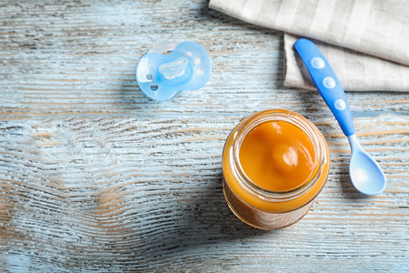 Jar with healthy baby food on wooden tableの写真素材
