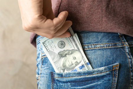 Woman getting out dollars from pocket, closeup