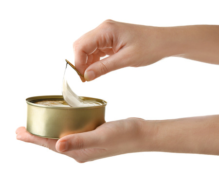 Woman opening tin can with fish on white background