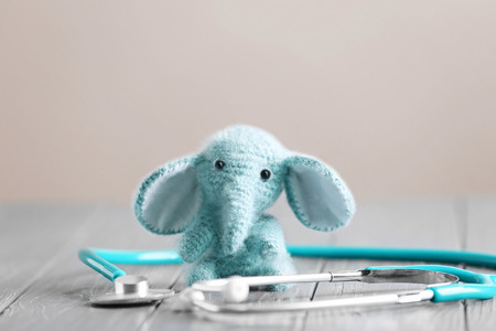 Toy elephant and stethoscope on table. Pediatrician conceptの写真素材