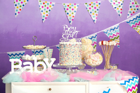 Boy or girl cake on buffet table at baby shower party
