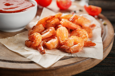 Fresh tasty shrimp basket and sauce on wooden board, closeupの写真素材