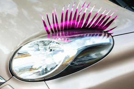 Car with eyelashes on headlight, closeupの写真素材