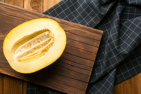 Board with yummy melon on wooden tableの写真素材