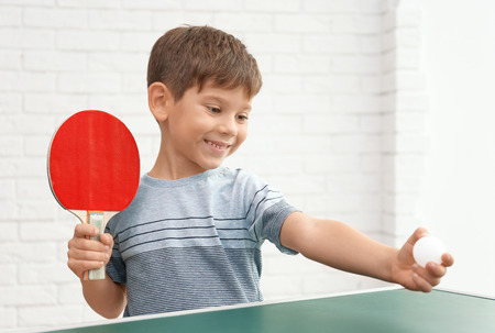 Cute little boy playing table tennis indoorsの写真素材