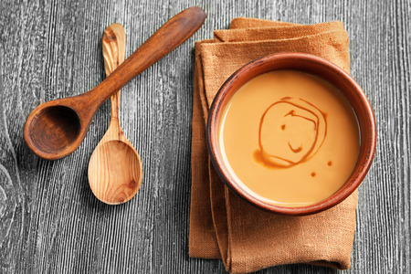 Bowl with sweet caramel sauce on tableの写真素材