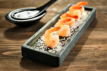 Plate with delicious grilled shrimps on wooden tableの写真素材