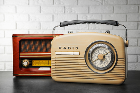 Retro radios on table near brick wallの写真素材