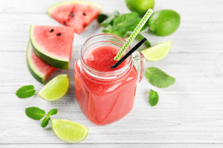 Mason jar with fresh watermelon smoothie on wooden tableの写真素材