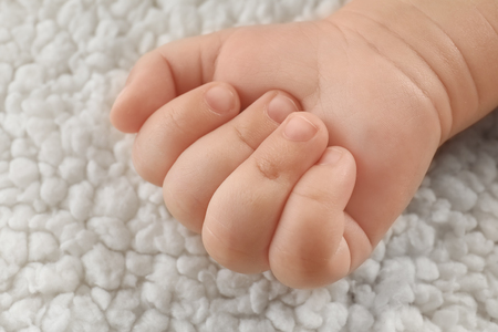 Baby hand on light plaid, closeupの写真素材