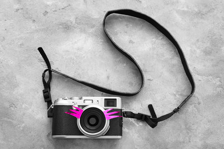 Vintage camera with eyelashes on tableの写真素材