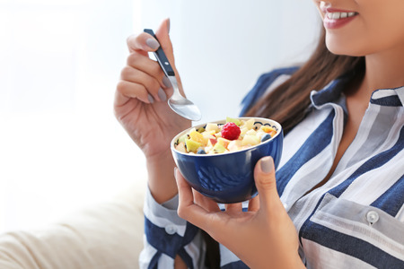 Young woman eating oatmeal, closeup