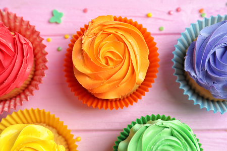 Tasty colorful cupcakes on wooden tableの写真素材