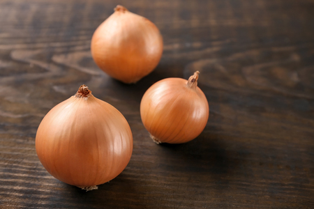 Fresh raw yellow onion on wooden backgroundの写真素材