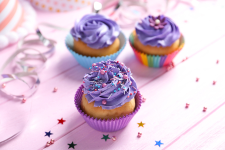Tasty colorful cupcakes on wooden tableの写真素材
