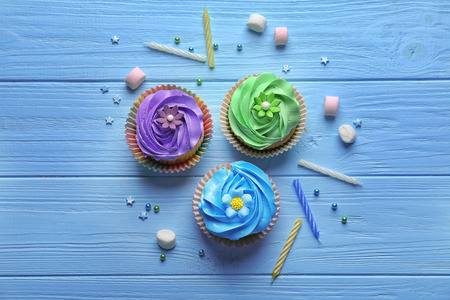 Tasty colorful cupcakes on wooden tableの写真素材