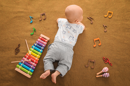 Cute boy with xylophone on color textileの写真素材