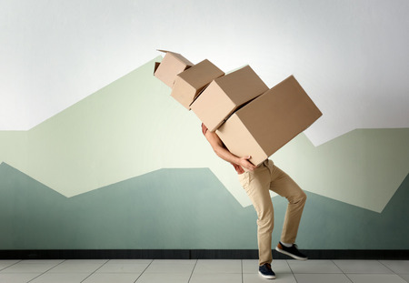Man with moving boxes near color wallの写真素材