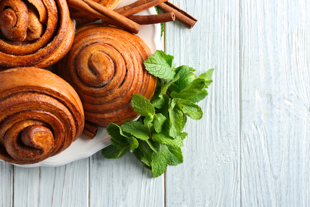 Plate with tasty cinnamon buns on tableの写真素材