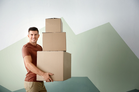 Man with moving boxes near color wallの写真素材